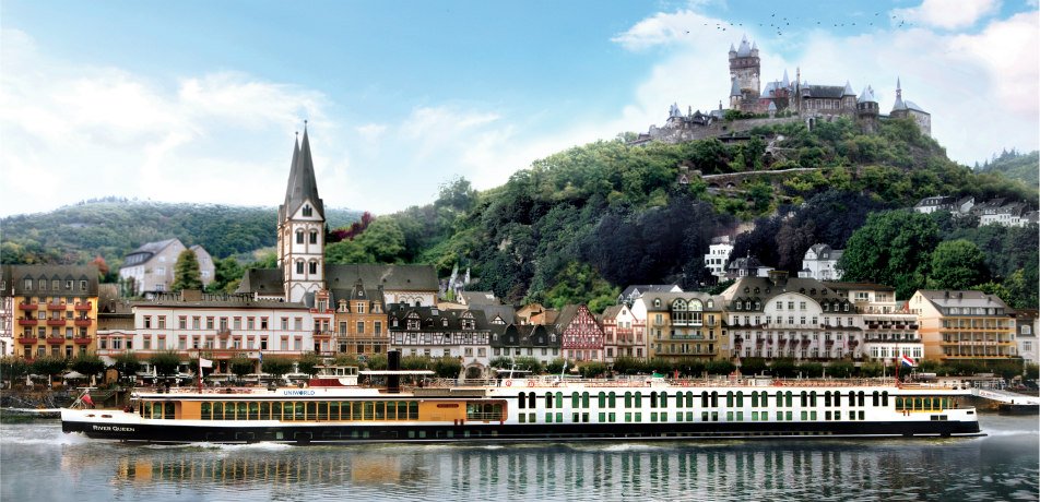 Reichsburg Cochem Castle overlooking the Rhine River with a river cruise ship passing the historic German town