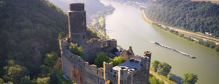Burg Maus castle overlooking the Rhine Gorge with river traffic below in the Upper Middle Rhine Valley Germany